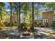 Serene backyard with a brick fire pit, lush trees, and a home's exterior, creating an ideal outdoor retreat at 112 Huckleberry Ln, Summerville, SC 29485