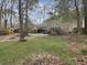 Spacious backyard showcasing a brick house, trees, and a wooden playset, creating a perfect setting for play and relaxation at 112 Huckleberry Ln, Summerville, SC 29485
