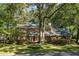 Charming two-story brick home with mature trees and red shutters on a sunny day at 112 Huckleberry Ln, Summerville, SC 29485