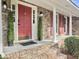 Welcoming front porch with brick steps, columns, a red door, and manicured topiaries at 112 Huckleberry Ln, Summerville, SC 29485