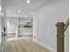 Hallway leading to a bright kitchen featuring new floors, white cabinets, and an island at 112 Huckleberry Ln, Summerville, SC 29485