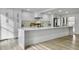 Modern white kitchen with a large island, stone backsplash, and stainless steel appliances at 112 Huckleberry Ln, Summerville, SC 29485