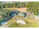 Aerial view showcasing the clubhouse and golf course with meticulously manicured fairways and sand traps at 1164 Out Of Bounds Dr, Summerville, SC 29485