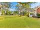 Extensive backyard with lush grass, mature trees and the side of the home in view at 1164 Out Of Bounds Dr, Summerville, SC 29485