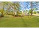 A large backyard with grass and trees around the property at 1164 Out Of Bounds Dr, Summerville, SC 29485