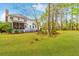 Expansive backyard with green grass, mature trees, and the rear view of the home at 1164 Out Of Bounds Dr, Summerville, SC 29485