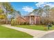Traditional brick home with a manicured lawn, circular driveway, and mature trees creating curb appeal at 1164 Out Of Bounds Dr, Summerville, SC 29485
