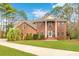 Stately brick home featuring a manicured lawn, prominent columns, and a grand entrance at 1164 Out Of Bounds Dr, Summerville, SC 29485