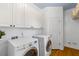 Bright laundry room with modern washer and dryer, white cabinets, and hardwood floors at 1164 Out Of Bounds Dr, Summerville, SC 29485