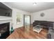 Cozy living room with a fireplace, television and sliding glass door to the back patio. Hardwood flooring throughout at 118 Alpine Rd, Summerville, SC 29485