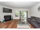 Cozy living room with a fireplace, television and sliding glass door to the back patio. Hardwood flooring throughout at 118 Alpine Rd, Summerville, SC 29485