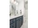 Bathroom vanity with a granite countertop and grey cabinets under bright lights and a large mirror at 122 Lucia St, Charleston, SC 29492