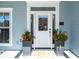 Close-up of the front door, featuring elegant detailing, sidelights, and potted plants, enhancing curb appeal at 122 Lucia St, Charleston, SC 29492