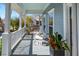 Relaxing front porch with white rocking chairs, a hanging plant, and a painted ceiling providing shade at 122 Lucia St, Charleston, SC 29492