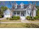 Charming two-story home featuring dormer windows, blue siding, a landscaped yard, and a welcoming front porch at 122 Lucia St, Charleston, SC 29492