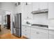 Modern kitchen features white cabinets, stainless steel appliances, and contrasting dark hardware, offering style at 122 Lucia St, Charleston, SC 29492