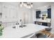 Bright kitchen with white cabinets, marble countertops, and a stainless steel faucet on a large island at 122 Lucia St, Charleston, SC 29492