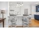 Stylish kitchen featuring an eat-in bar, white cabinets, hardwood floors, and modern lighting fixtures at 122 Lucia St, Charleston, SC 29492