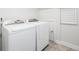 Bright laundry room with a washer and dryer on a tile floor near an access door at 122 Lucia St, Charleston, SC 29492