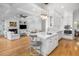 Open concept living room and kitchen with white cabinetry, stainless appliances, fireplace, and hardwood floors at 122 Lucia St, Charleston, SC 29492