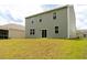 View of the home's rear facade with a spacious backyard, siding and glass doors leading to the lawn at 131 Cloverleaf St, Summerville, SC 29483