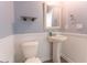Stylish half bath featuring a pedestal sink, framed mirror, and updated lighting at 131 Cloverleaf St, Summerville, SC 29483