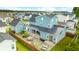 Aerial view of a blue home with a fenced-in backyard, patio with outdoor seating, and manicured lawn at 141 Sandy Bend Ln, Summerville, SC 29486