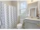 Cozy bathroom featuring a shower with patterned curtain, toilet, and vanity with natural light from the window at 141 Sandy Bend Ln, Summerville, SC 29486