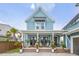 Charming two-story home with a light blue exterior, inviting front porch, and beautiful landscaping at 141 Sandy Bend Ln, Summerville, SC 29486