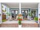 Inviting front porch features comfortable wooden chairs, plants, and an inviting view through french doors at 141 Sandy Bend Ln, Summerville, SC 29486