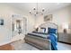 A beautifully styled bedroom boasts hardwood floors, an ensuite bathroom, and a decorative chandelier at 141 Sandy Bend Ln, Summerville, SC 29486