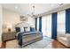 The primary suite features a luxurious upholstered headboard, stylish decor, and access to natural light at 141 Sandy Bend Ln, Summerville, SC 29486