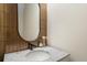 Modern powder room with decorative bronze tiling, marble countertop, and a stylish round mirror at 141 Sandy Bend Ln, Summerville, SC 29486