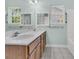 Bright bathroom featuring double sinks, a window overlooking the exterior, and wood cabinets at 1429 Swamp Fox Ln, Charleston, SC 29412