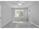 Bright bedroom featuring a ceiling fan, gray walls and flooring, and a large window overlooking the exterior at 1429 Swamp Fox Ln, Charleston, SC 29412