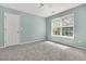 Bedroom featuring a ceiling fan, blue walls and carpeted floor, and a large window overlooking the exterior at 1429 Swamp Fox Ln, Charleston, SC 29412