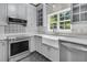 Well-lit kitchen featuring gray cabinets, stainless steel appliances, and a farmhouse sink at 1429 Swamp Fox Ln, Charleston, SC 29412