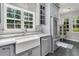 Stylish kitchen with gray cabinets, stainless steel refrigerator, and a farmhouse sink at 1429 Swamp Fox Ln, Charleston, SC 29412