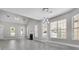 Expansive living room with tall ceilings, multiple windows, gray flooring, and a modern pendant light fixture at 1429 Swamp Fox Ln, Charleston, SC 29412