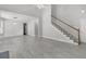 Bright living room boasts tall ceilings, a staircase, gray flooring, and flows seamlessly into other living spaces at 1429 Swamp Fox Ln, Charleston, SC 29412