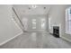 Bright and airy living room featuring a fireplace, staircase, and ample natural light from large windows at 1429 Swamp Fox Ln, Charleston, SC 29412