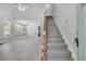 Spacious living area with staircase, light gray floors, ample windows, and open flow to dining room and kitchen at 1429 Swamp Fox Ln, Charleston, SC 29412