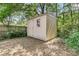 Backyard shed with a small window surrounded by leafy green trees and sparse ground cover at 1429 Swamp Fox Ln, Charleston, SC 29412