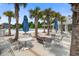 Outdoor dining area with a fire pit and a view of the pool surrounded by palm trees at 143 West Bradford Pointe Dr, Summerville, SC 29486