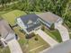 Aerial view showcasing a green two-story home with manicured lawns, driveway, and surroundings at 1489 Brockenfelt Dr, Charleston, SC 29414