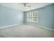 Light-filled bedroom boasts neutral carpet, a ceiling fan, and a window with bright blue walls at 1489 Brockenfelt Dr, Charleston, SC 29414