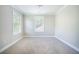 A bright bedroom features two windows, light-colored walls, trim, and carpet at 1489 Brockenfelt Dr, Charleston, SC 29414