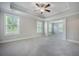 Spacious bedroom featuring tray ceilings, neutral walls, plush carpet, and bright natural light from multiple windows at 1489 Brockenfelt Dr, Charleston, SC 29414