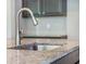 Close-up of a stainless steel kitchen sink featuring a gooseneck faucet and granite countertops at 1489 Brockenfelt Dr, Charleston, SC 29414