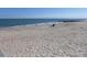 Expansive sandy beach with gentle waves and people enjoying the ocean at 1603 Lybrand St, Edisto Island, SC 29438